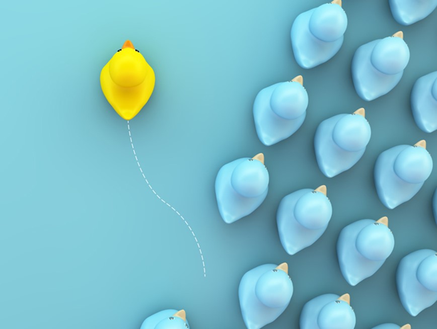 Image of a yellow rubber duck moving away from a pack of blue rubber ducks against a blue background