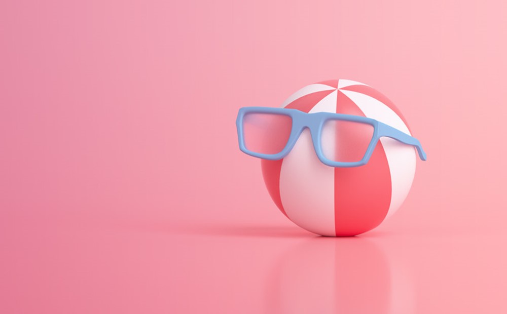 Image of a red a white beach ball wearing blue glasses against a pink background 