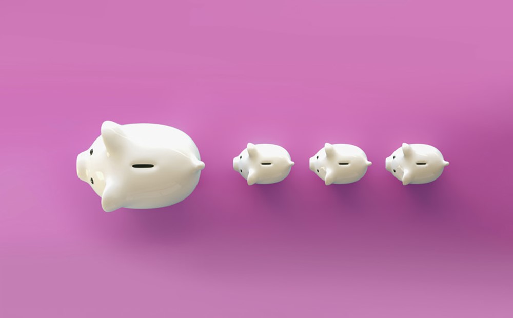 Image of piggy banks in a line on a pink background