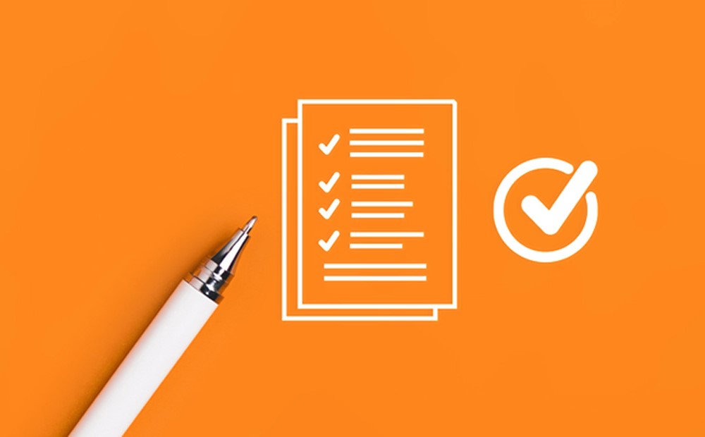 A white pen and a white outline of a checklist against an orange background