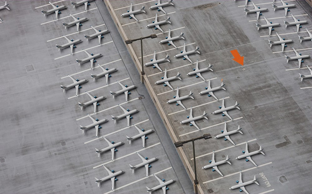 Image of airplanes parked with an orange arrow on the tarmac