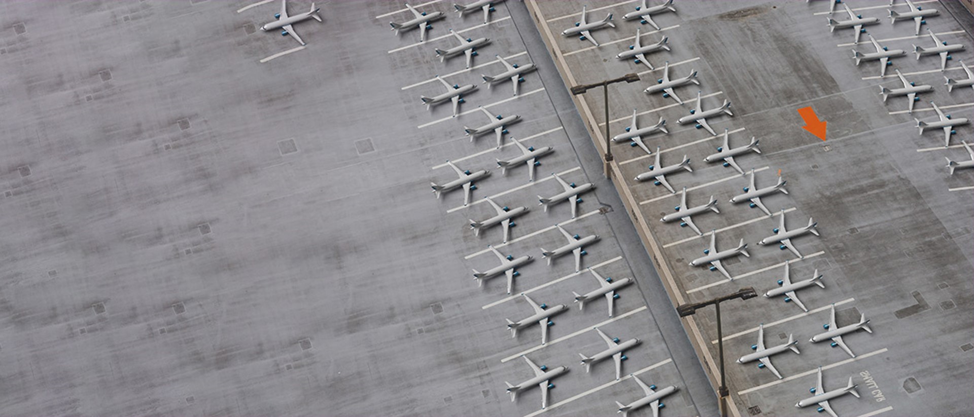Image of airplanes parked with an orange arrow on the tarmac