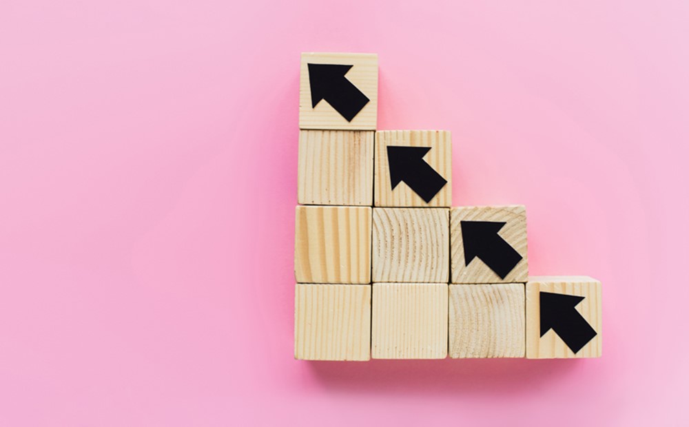 Image of wooden blocks going diagonally against a pink background