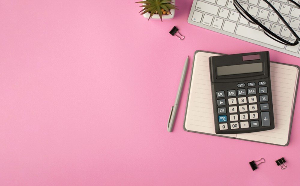 Image of a calculator and planner on a pink background
