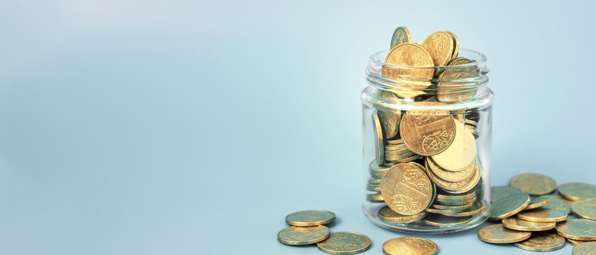 Image of coins in a glass jar on a blue background