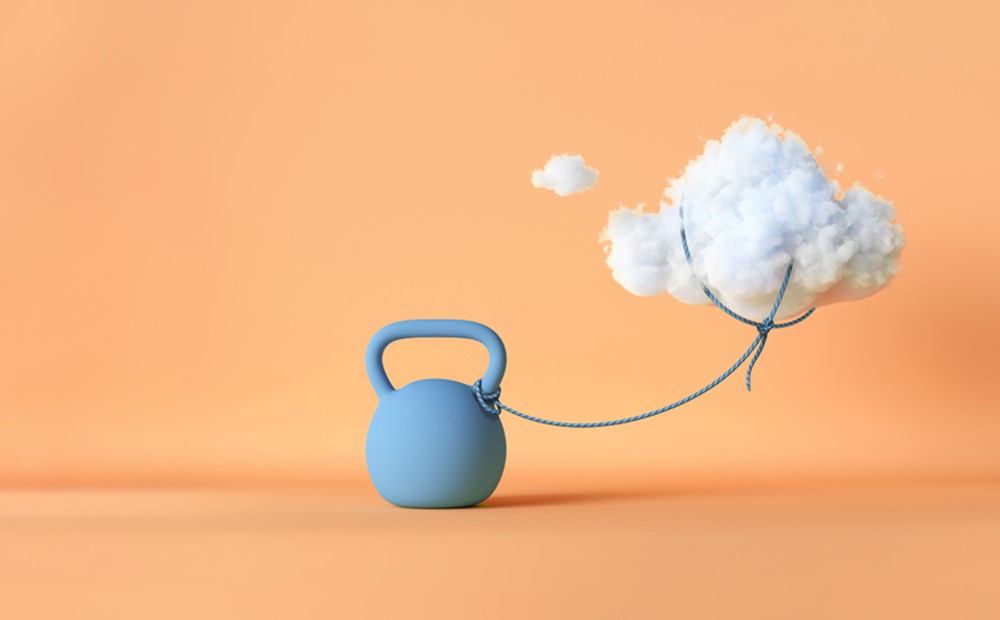 Image of a cloud tied down with a blue weight, against an orange background
