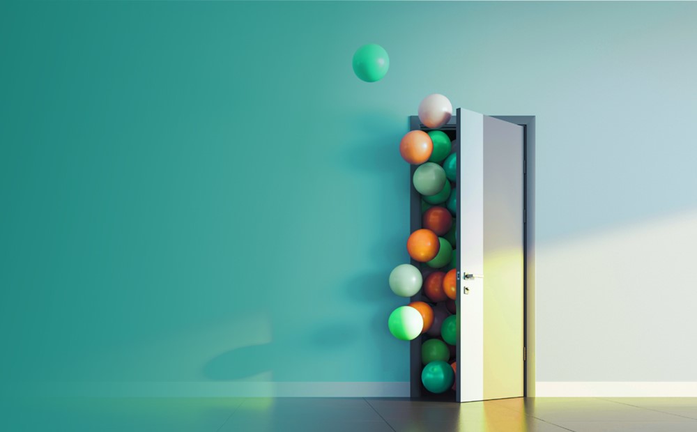 Image of a door with balloons coming out with a teal background