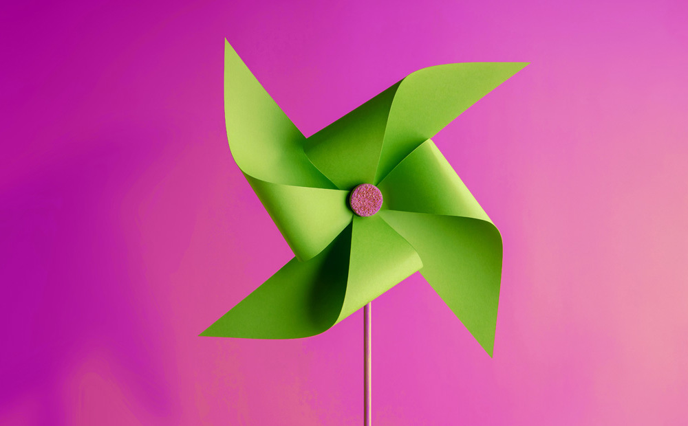 Image of a green paper fan against a purple background