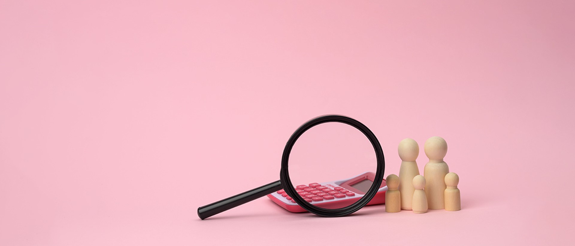Image of a magnifying glass, a calculator and wooden figures of a family on a pink background