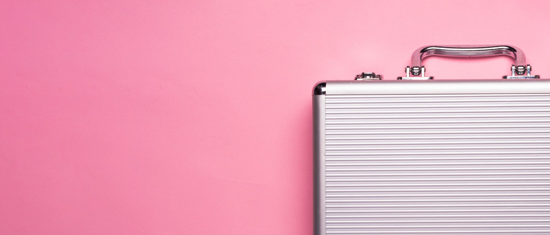 A silver briefcase against a pink background