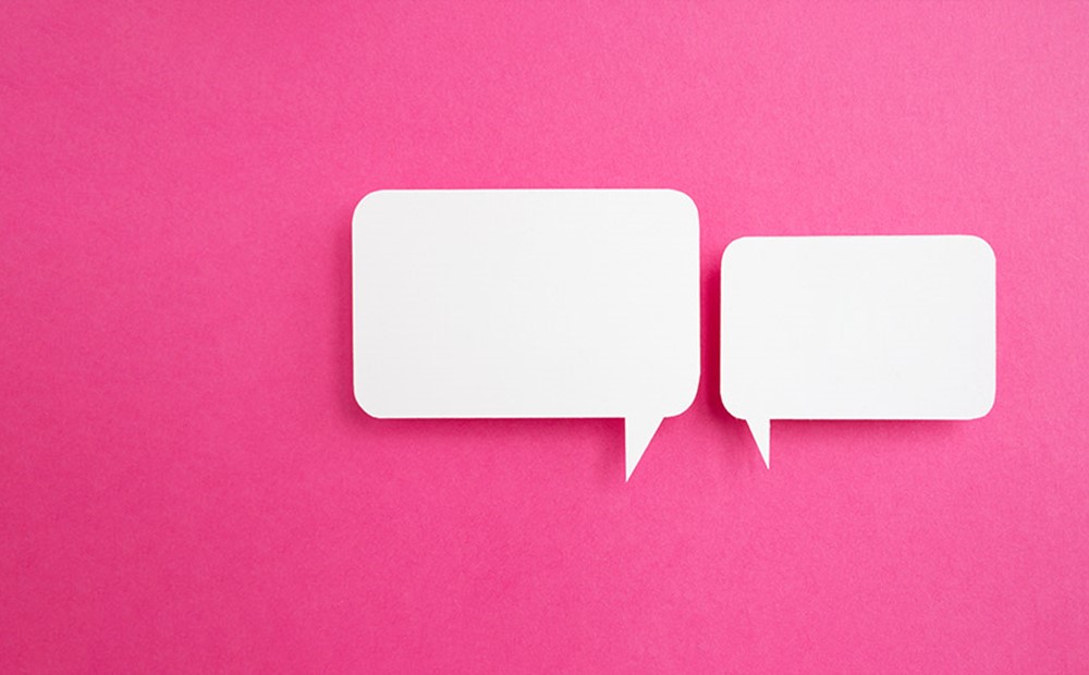 Image of two white speech bubbles on a pink background