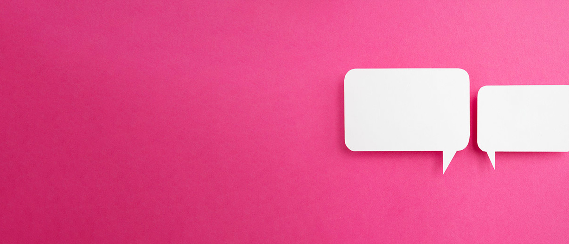 Image of two white speech bubbles on a pink background