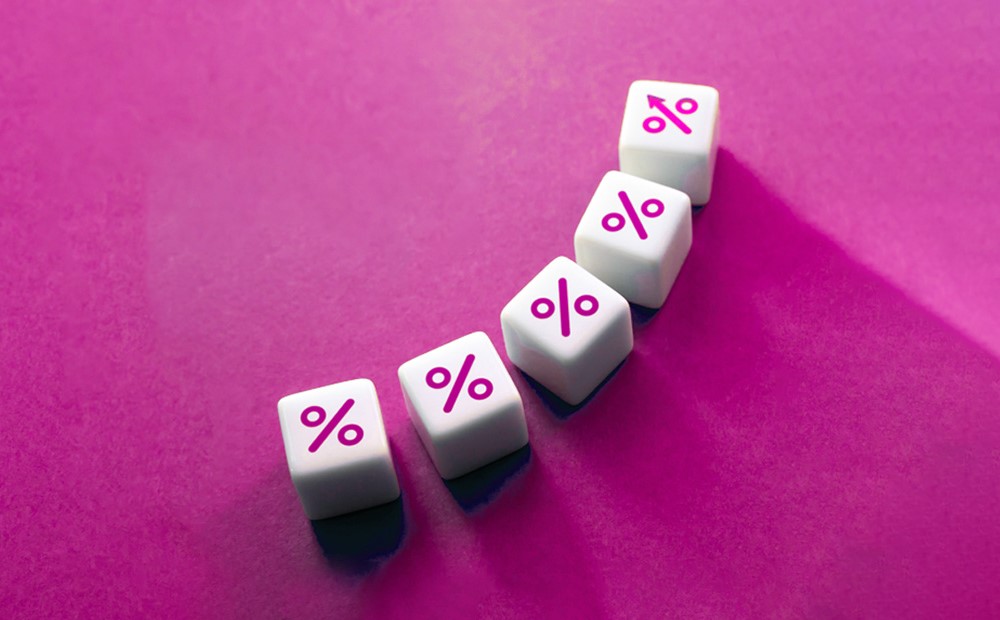 Five dice with a percentage symbol on each against a purple background