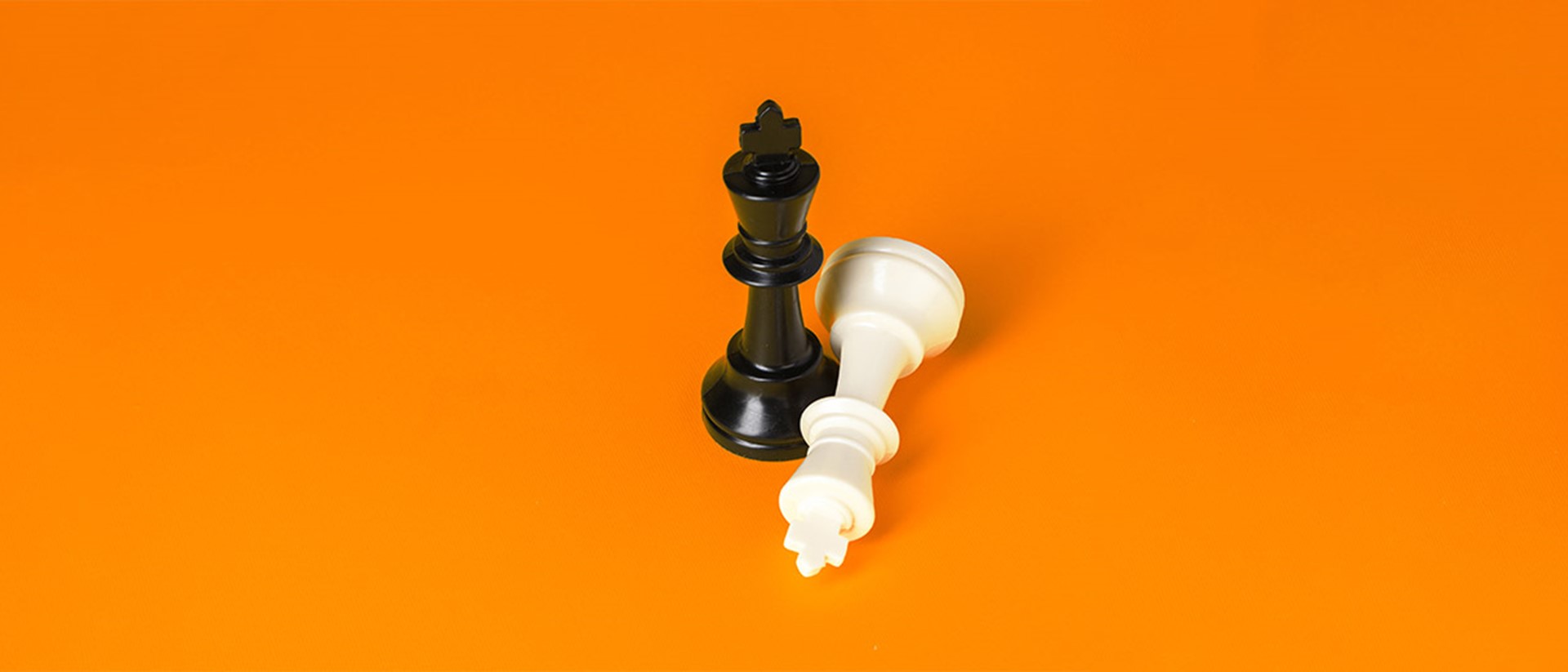 Hero image of chess pieces on an orange background