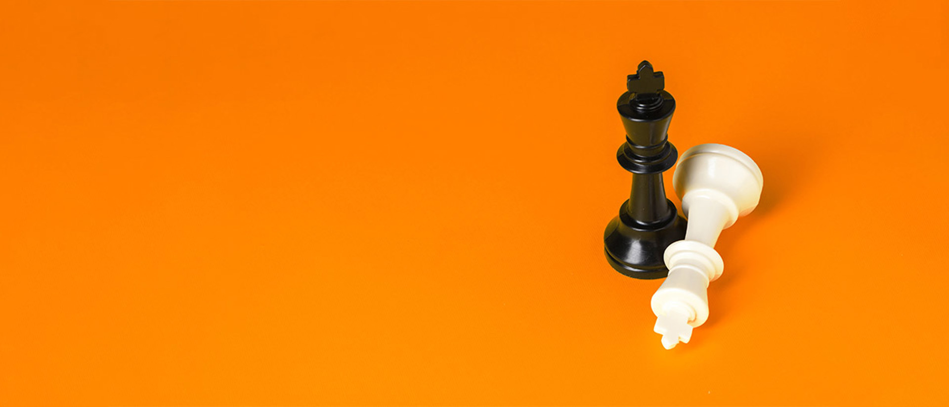 Hero image of chess pieces on an orange background