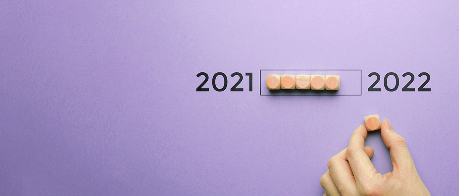 Image wooden blocks being moved from 2021 to 2022 on a purple background