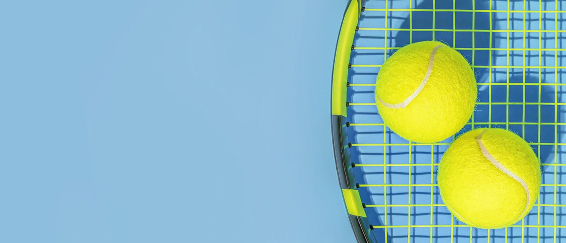 Image of two tennis balls on a tennis racket against a blue background