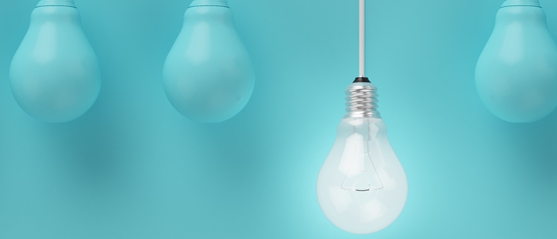 Image of a lightbulb hanging down with blue lightbulbs either side on a teal background