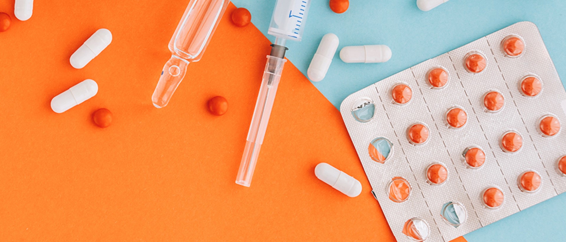 Image of syringes and pills on an orange and teal background