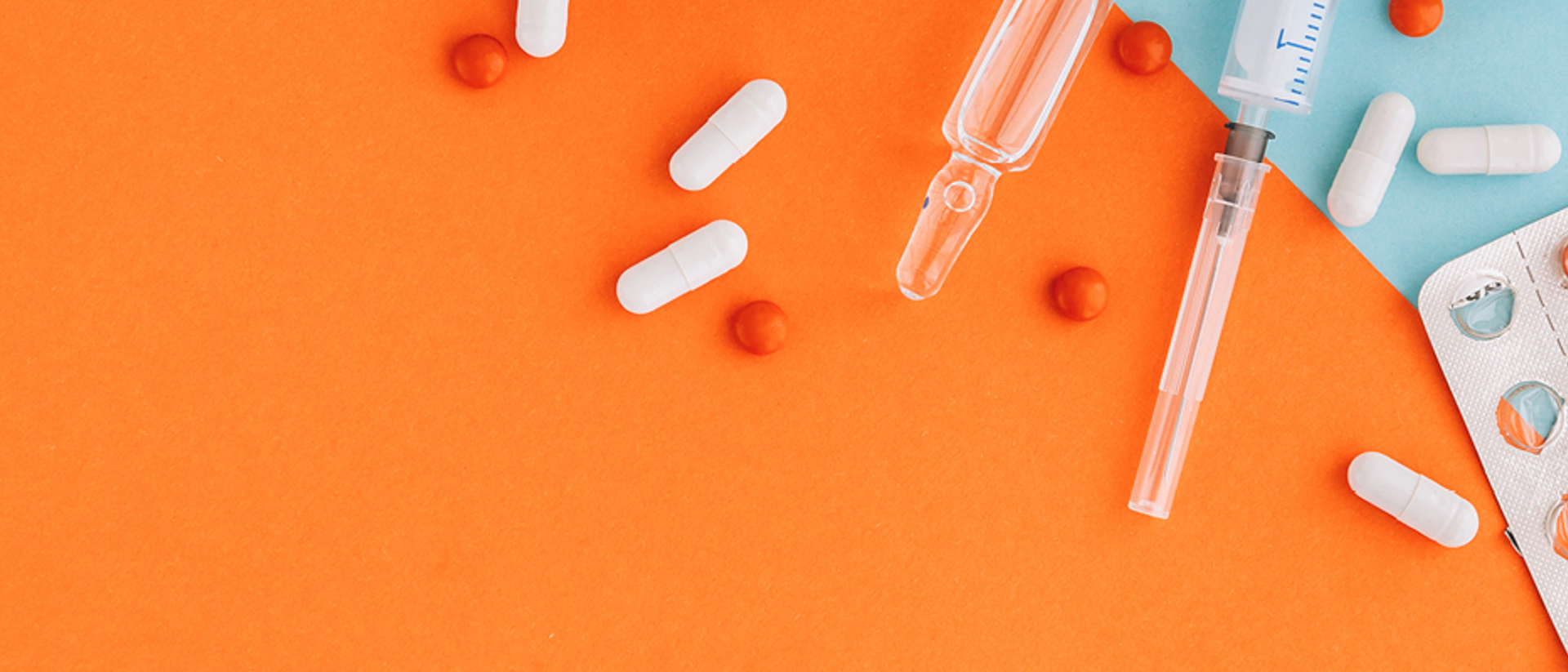 Image of syringes and pills on an orange and teal background