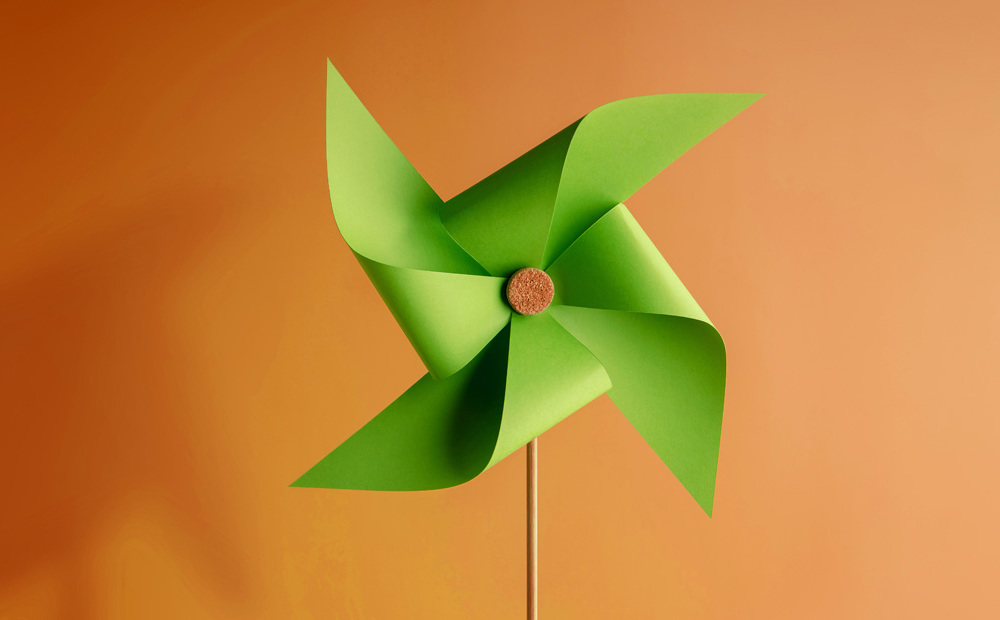 Image of a green paper fan against an orange background