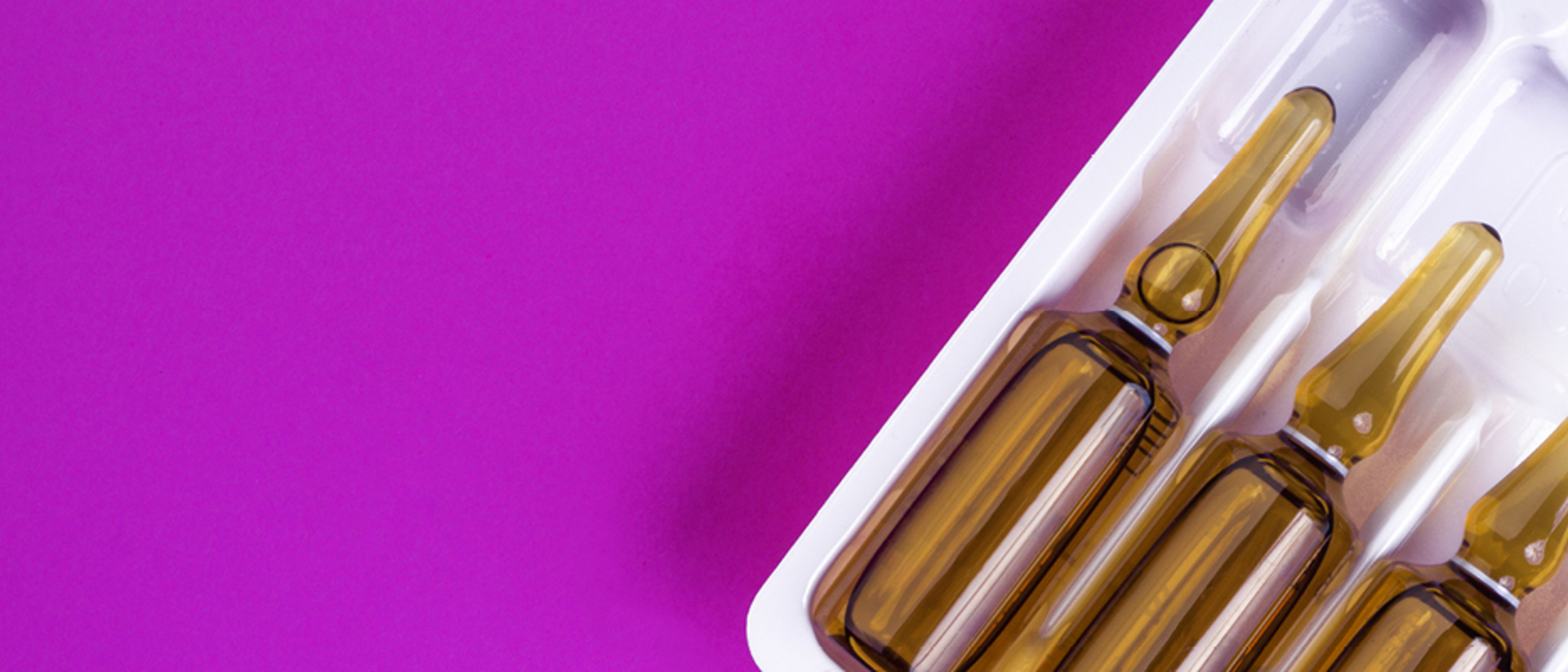 Image of glass vials on a pink background