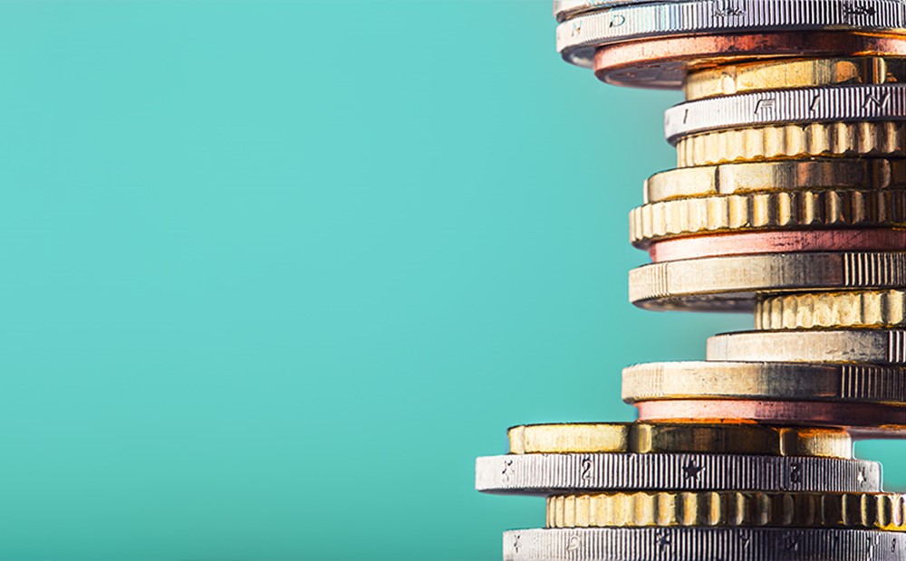 Image of stacked coins on a teal background