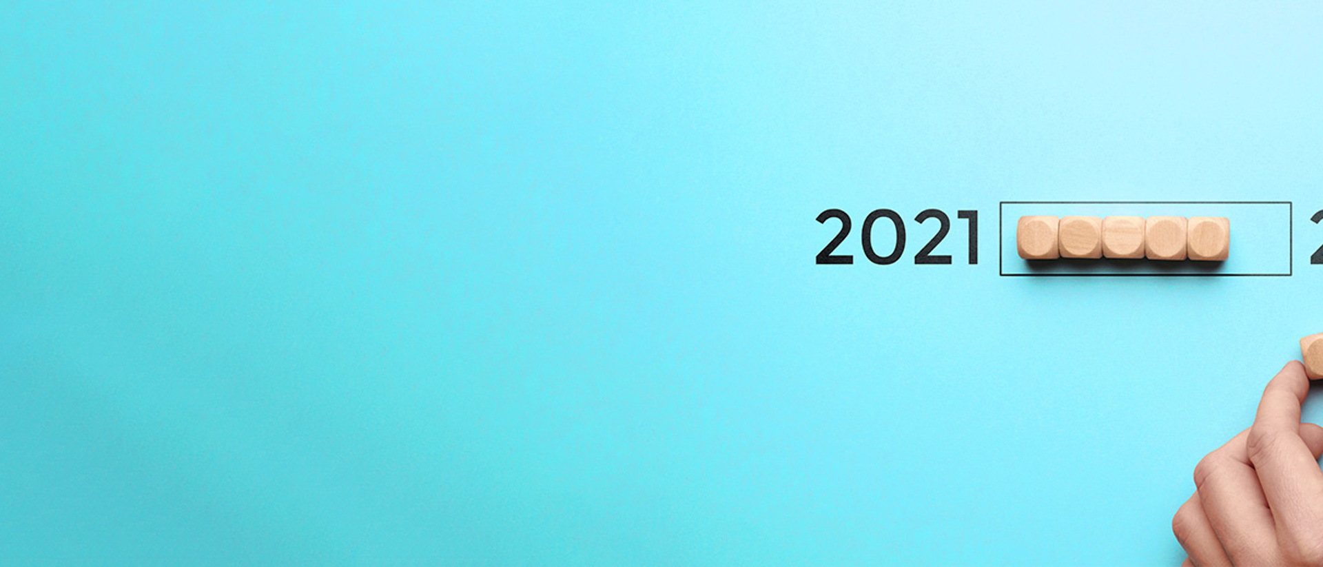 Image wooden blocks being moved from 2021 to 2022 on a blue background