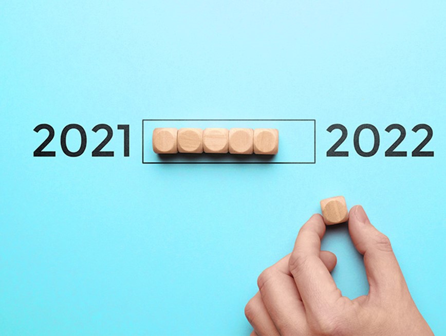 Image wooden blocks being moved from 2021 to 2022 on a blue background