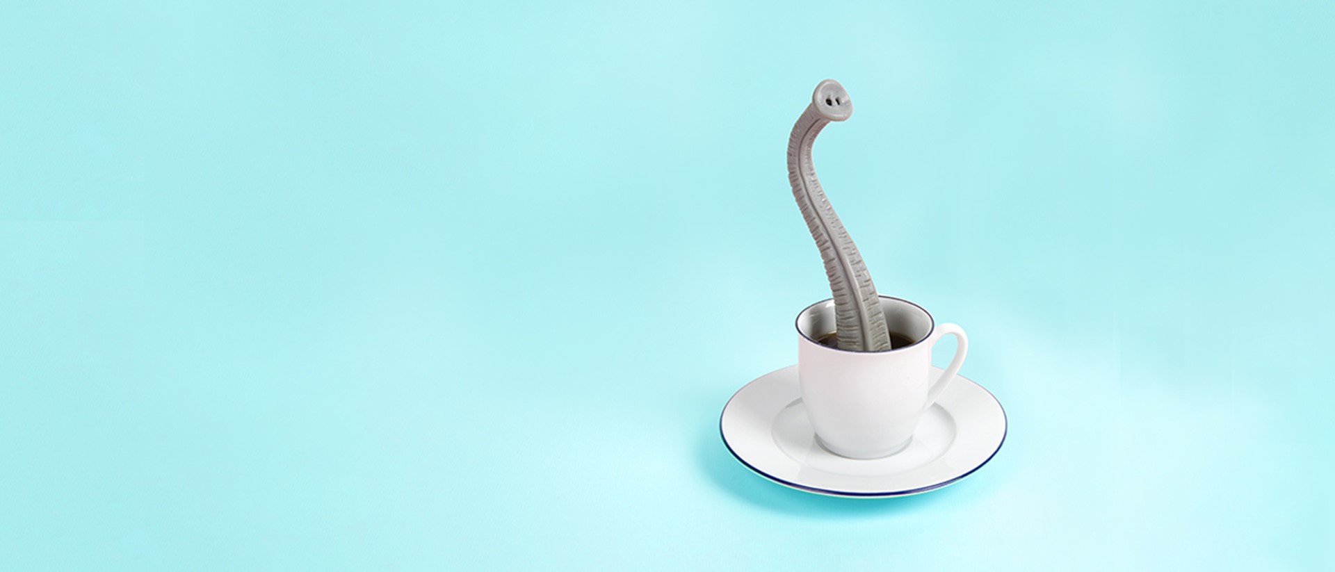 Image of an elephant trunk rising up out of a tea cup on a light blue background