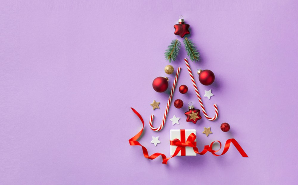 Image of Christmas items forming a shape of a Christmas tree against a purple background