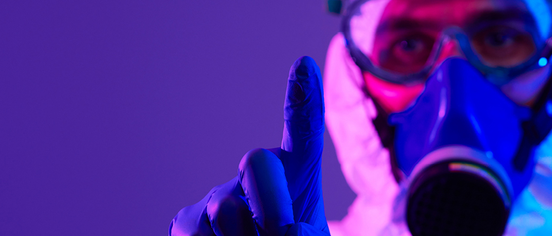 Image of man with a purple glove, wearing a gas mask on a purple background