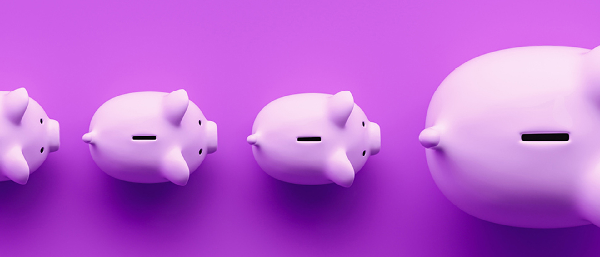 Image of piggy banks in a line on a purple background