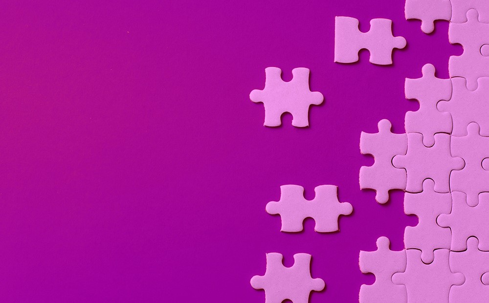 Image of pink jigsaw pieces on a purple background